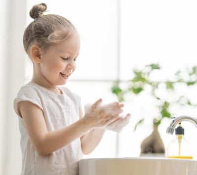Girl washing her hands in sink