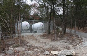 Two propane tanks in an enclosed fence at Big Cedar