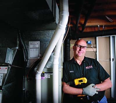 A construction worker by a furnace in a basement