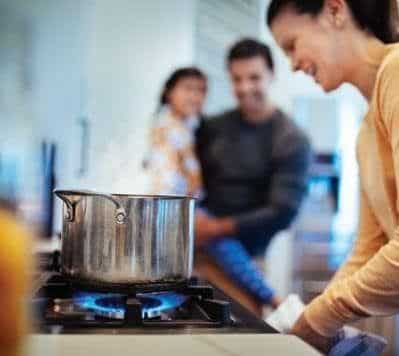 Woman cooking on a propane kitchen range