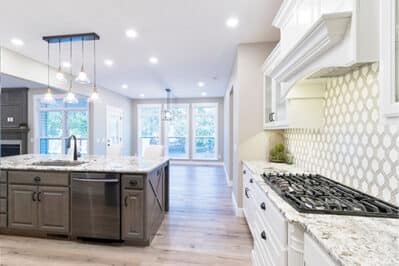 View of the kitchen with propane gas stove and the fireplace across the room