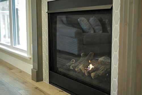 A propane fireplace burning by a window