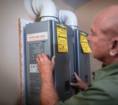 Man inspecting propane hot water heater
