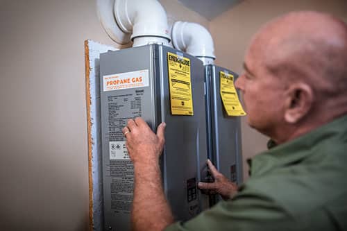 Technician inspects propane tankless water heaters